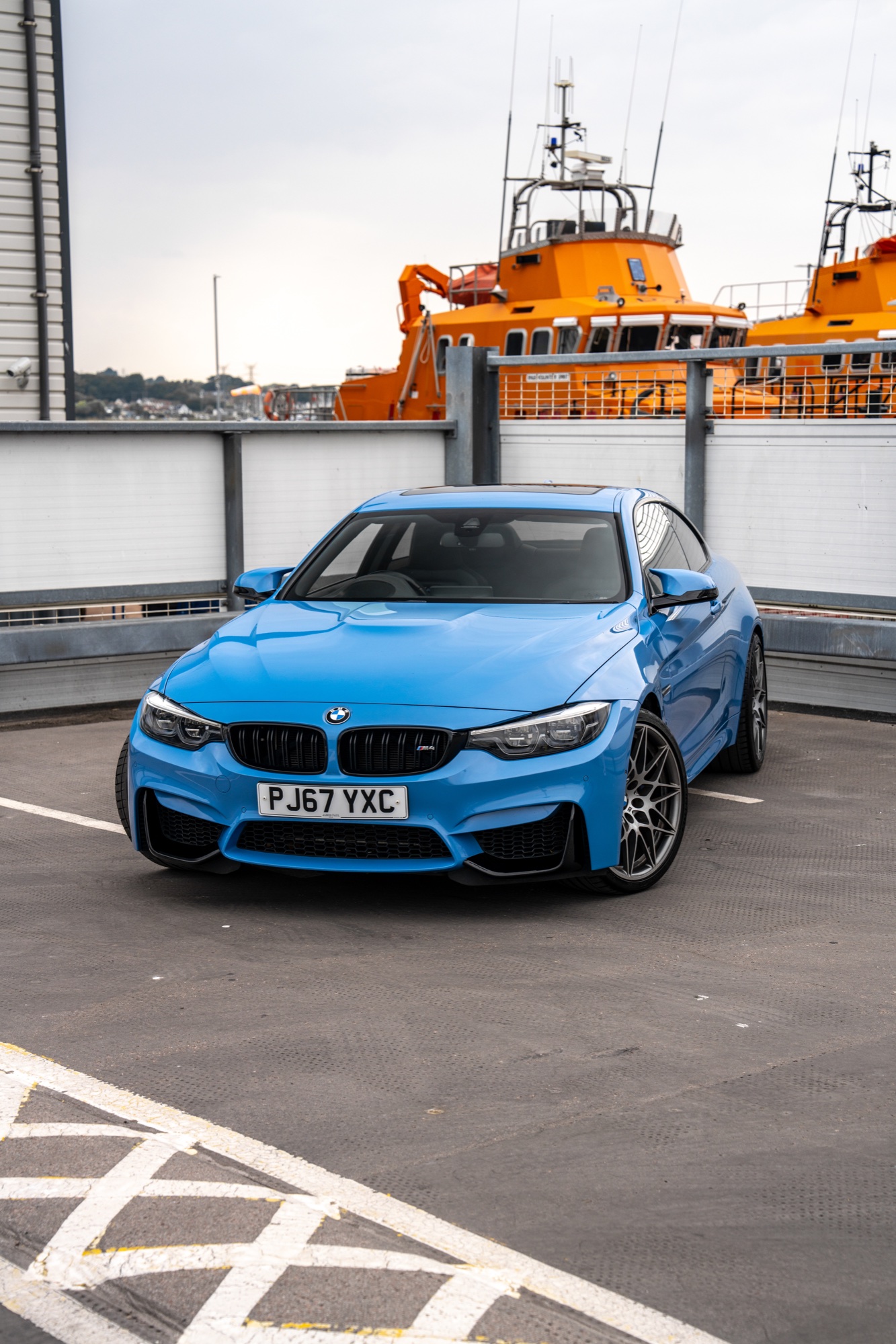 Blue BMW photographed against orange harbour architecture